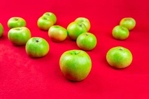 Green apples on a red background Stock Photos
