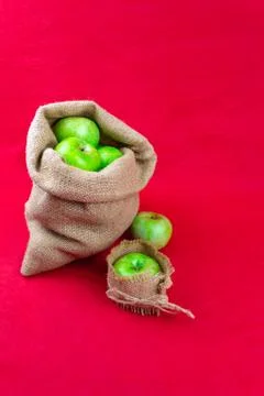 Green apples on a red background Foto stock