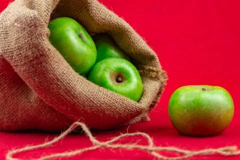 Green apples on a red background Foto stock