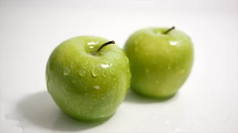 Green apples on white background splashed with drops of water. Stock Footage 99261195