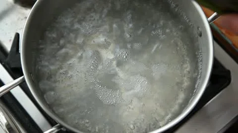 Green asparagus being added to a pot of boiling water Stock Footage 24672280