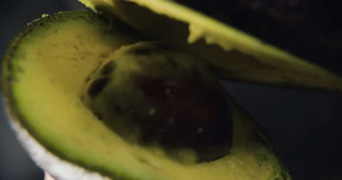 Green avocado divided in half in the hands in slow motion in 4k Stock Footage 101285211