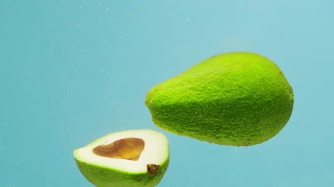 Green avocado dropping in water, fresh fruits and vegetables falling splashing Stock Footage 237173342