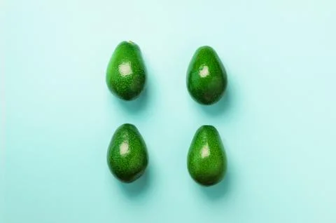 Green avocado pattern on blue background. Top view. Pop art design, creative Stock Photos