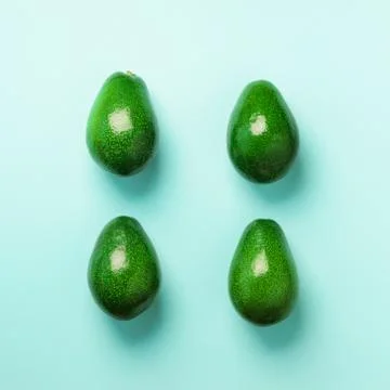 Green avocado pattern on blue background. Top view. Pop art design, creative Stock Photos