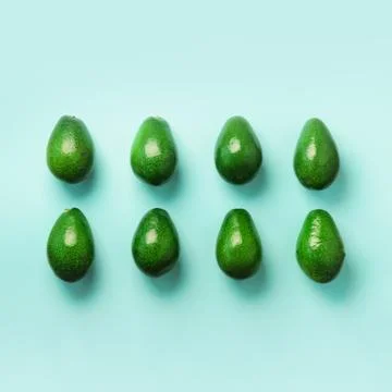 Green avocado pattern on blue background. Top view. Pop art design, creative Foto stock