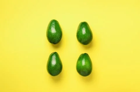 Green avocado pattern on yellow background. Top view. Pop art design, creative Foto stock