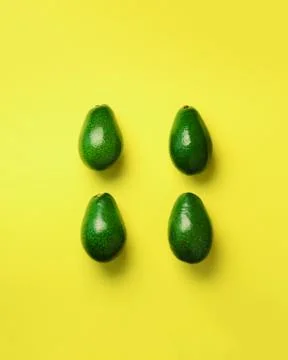Green avocado pattern on yellow background. Top view. Pop art design, creative 스톡 사진