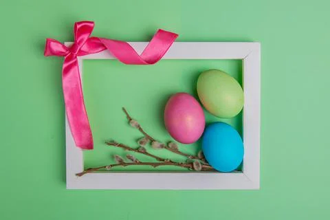 On a green background bow and easter eggs in a white frame Stock Photos