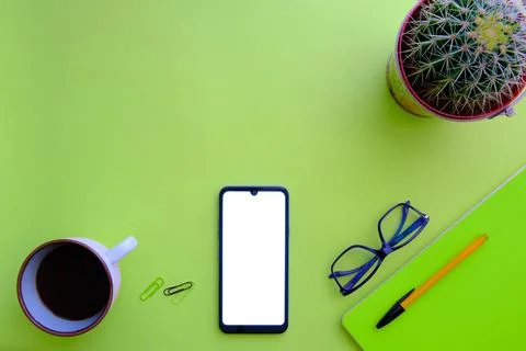 Green background with cell phone, notebook, coffee and glasses Stock Photos