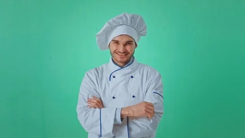 Green background charismatic baker guy in the uniform of baker posing in front Stock Footage 125488143