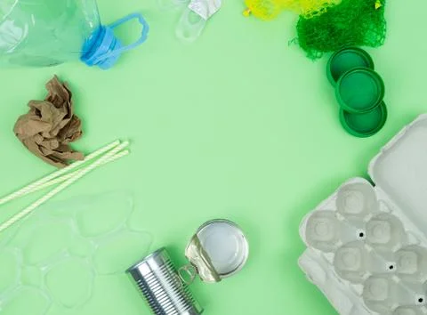 Green background with garbage objects for recycling and space in the center. Stock Photos