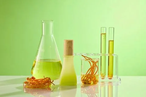 On the green background, lab equipments containing cordyceps and essence deco Stock Photos