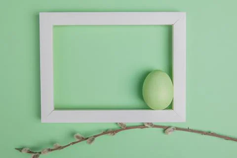 On a green background one easter eggs in a white frame Stock Photos