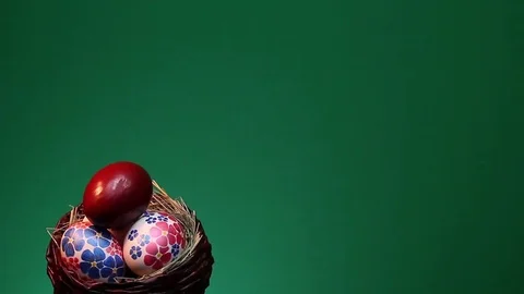 On a green background revolves wicker basket with hand-painted Easter eggs Stock Footage 73109233