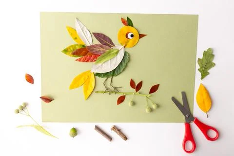 Green background showcases a creative craft. Bird formed from leaves, yello.. Foto stock