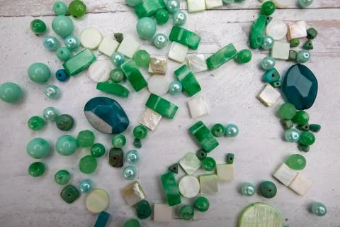 Green background texture jade beads and random gem stones Stock Photos