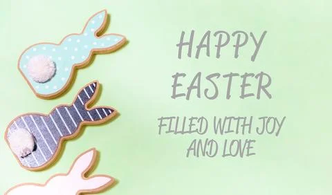 Green background with three Easter bunny cookies on it Stockfoto's