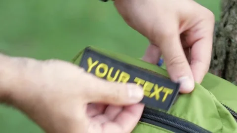On the green backpack stick a patch with the inscription your text. Yellow Stock Footage 76910096