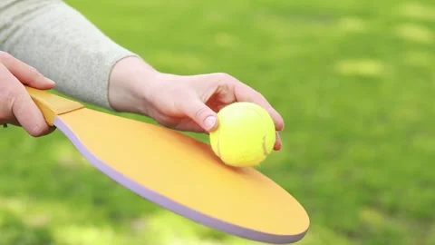 A green ball and a bright racket for playing tennis in the fresh air Stock Footage 241104010