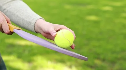 A green ball and a bright racket for playing tennis in the fresh air Stock Footage 241104142