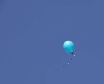 A green balloon on a blue sky Stock Photos