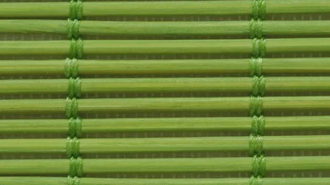 Green bamboo mat close up in slow motion moving down endless seamless pattern. Stock Footage 128506152