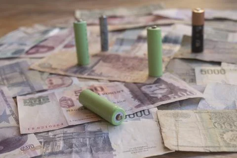 Green batteries on global money symbolizing sustainable energy economy Foto stock
