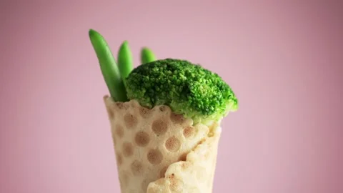 Green beans and broccoli in a waffle cup rotate on a pink background. Stock Footage 149665756
