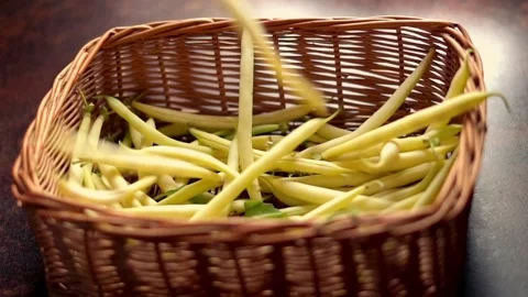 Green beans falling into wicker basket, slow motion Stock Footage 114820489
