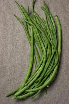 Green beans. Green string beans lie on a jute fabric. Stock Photos