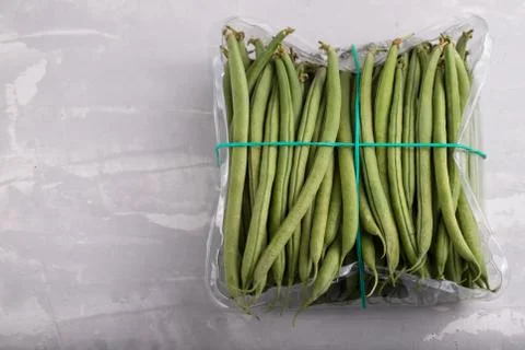 Green beans in plastic box on ceramic background Stock Photos