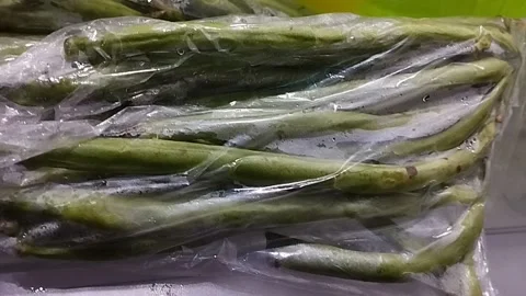 Green beans wrapped in plastic for resale Stock Footage 229553759