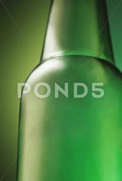 Green Beer Bottle On A Green Background; Close Up