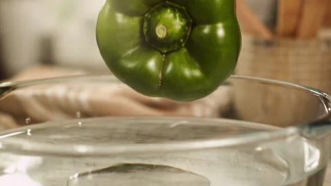 Green bell pepper falling into water in slow motion Stock Footage 152904527