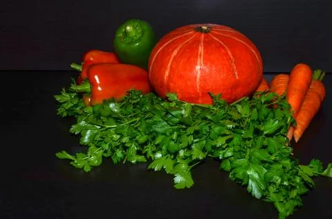 Green bell pepper, orange pumpkin, carrots, parsley Stock Photos