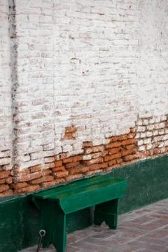 Green bench next to an old bricks wall Stock Photos