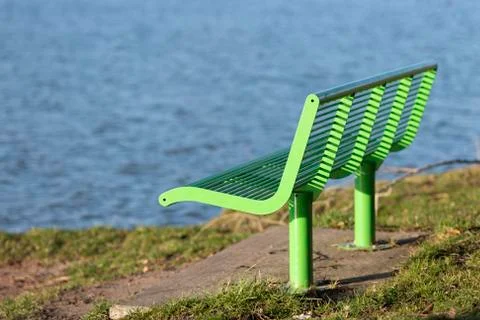 Green bench on the waterfront. Stock Photos