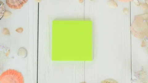 Green blank sheet and seashells on wooden background.Travel background Stock Photos