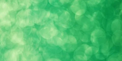 Green blurred abstract background. Defocus light glitter. Stock Photos
