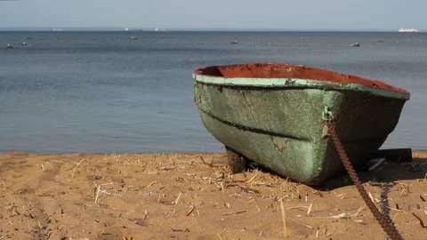 Green boat on a chain, on a sandy beach. the sea is calm. static background Stock Footage 122523545