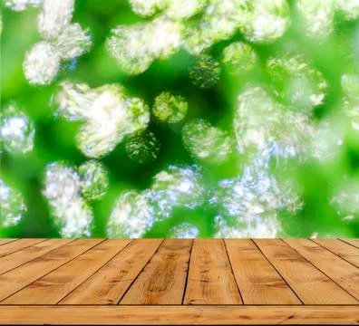 Green bokeh abstract light background, a lot forest bokeh with wood table Stock Photos