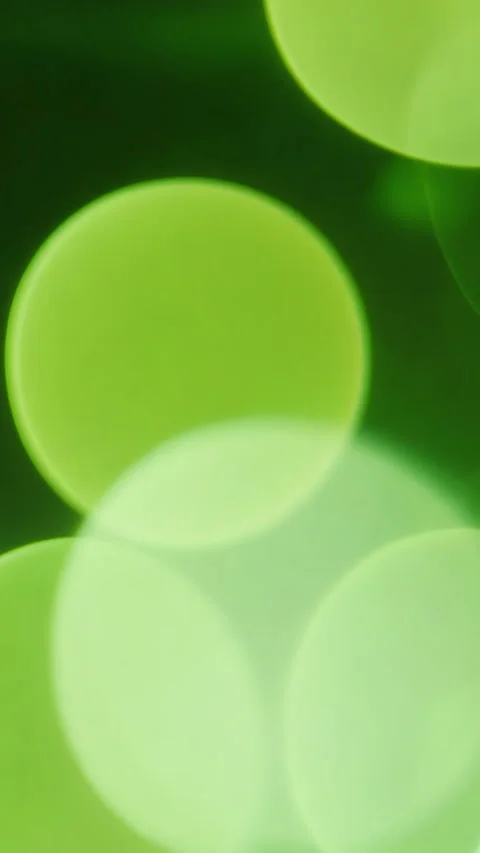 Green bokeh background displaying soft blurred lights effect. Vertical video. Stock Footage 310228875