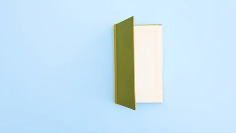 Green book appear and opens on first page - Stop motion Stock Footage 129477450