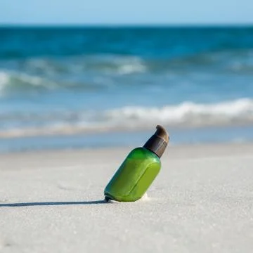 Green bottle on the beach Stock Photos