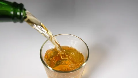 A green bottle of beer bubbles  poured into a glass with a slice of lime  Stock Footage 88509155