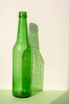 Green bottle on the green surface under the natural light of the sun, the sha Stock Photos