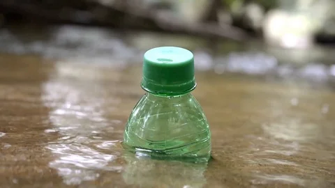 Green bottle stuck in river Stock Footage 95421542