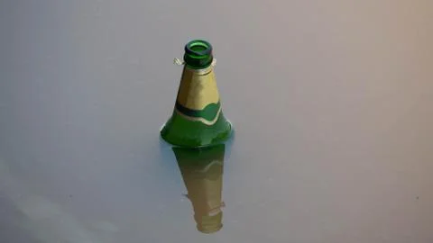 Green bottle was left floating in the river. Stock Photos