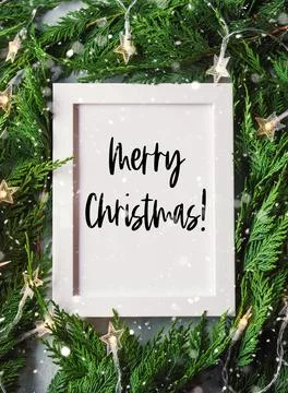 Green branches with star shape lights, frame wishing Merry Christmas Stock Photos